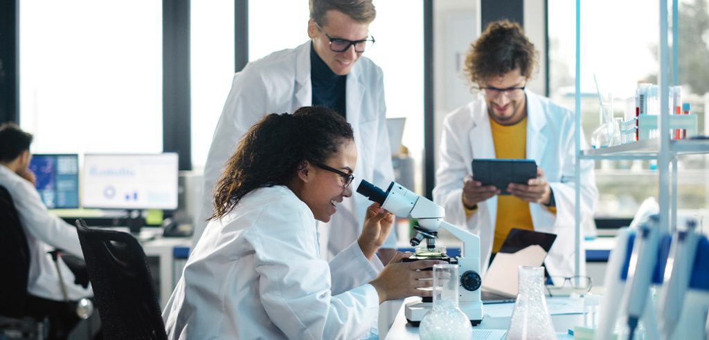 Lab Workers examining samples with a microscope